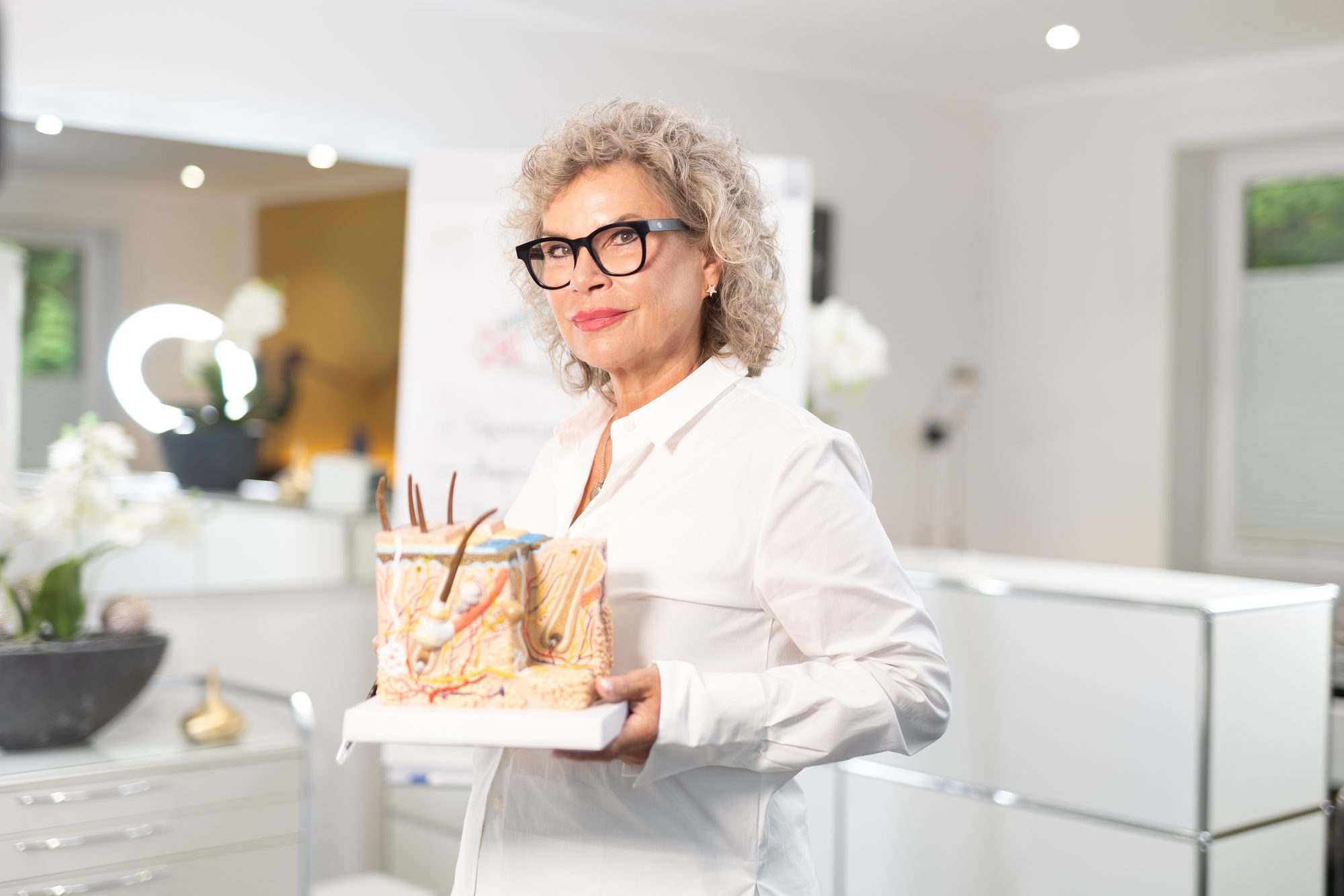 Sabine Bundschuh mit einem anatomischen Hautmodell in ihrem Ausbildungsstudio